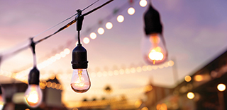 Close-up of hanging string lights with glowing bulbs against a blurred background